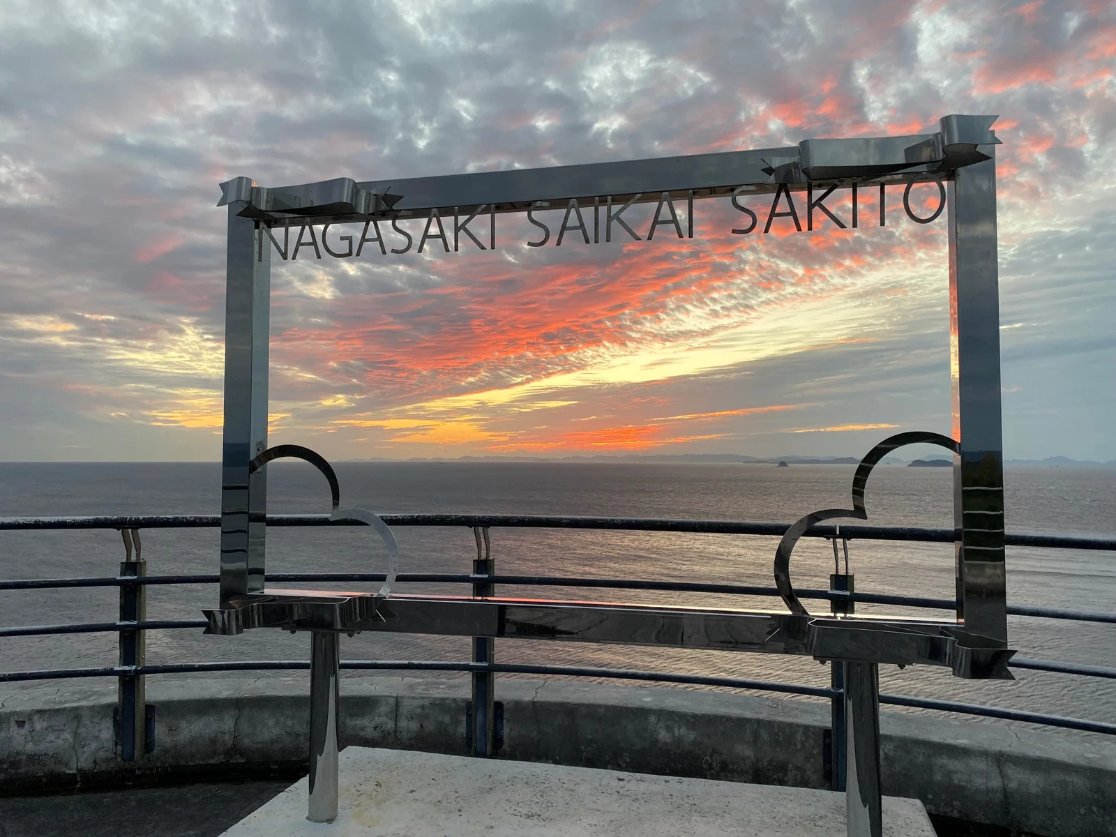 展望台のフレーム越しに望む夕空と海
